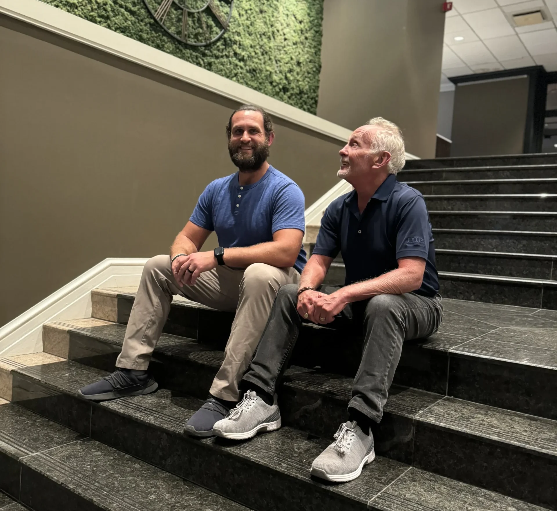 Jesse and Arnie seated on the stairs of their insurance office.