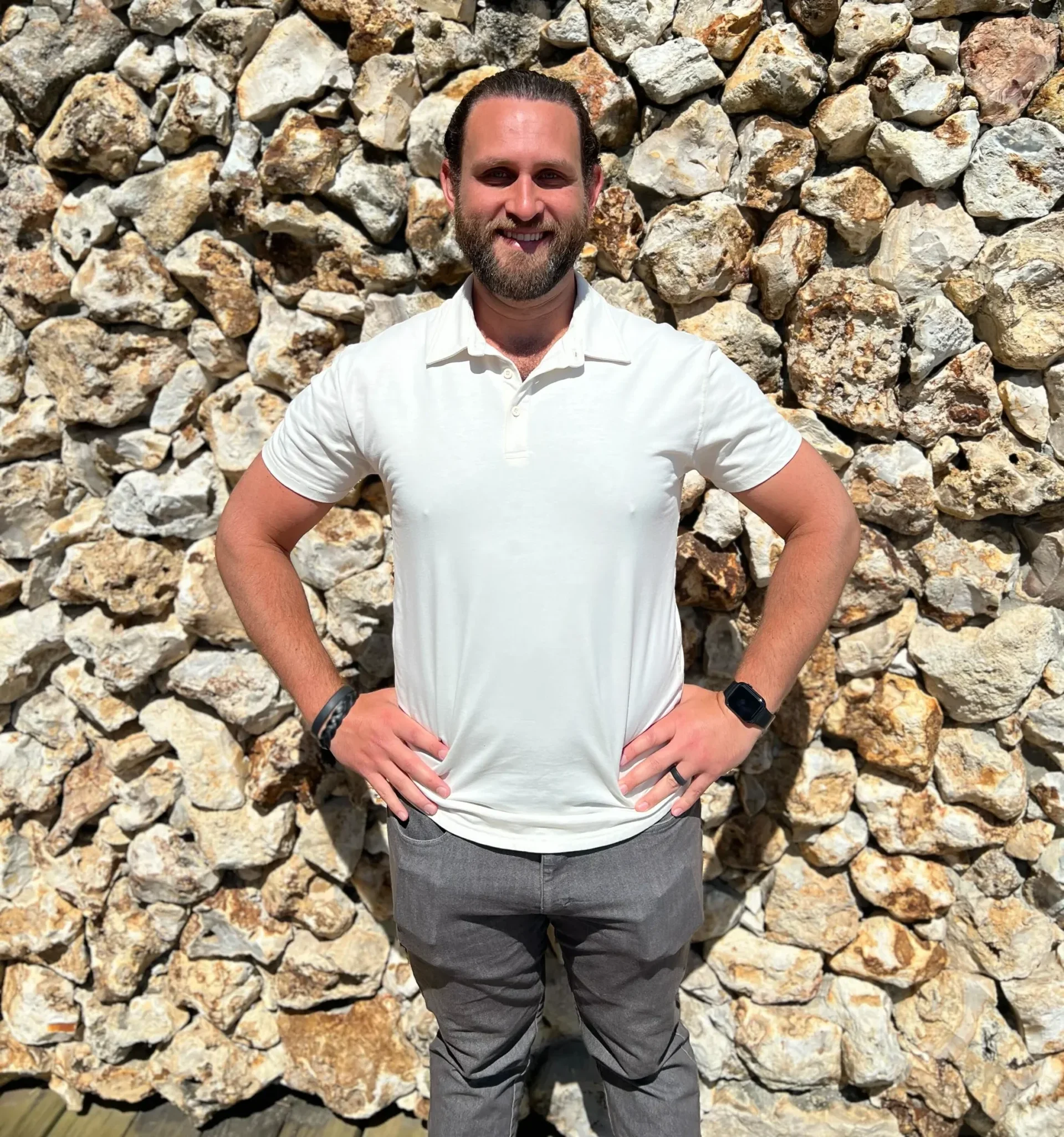 Jesse Peltz, Medicare expert, outdoors with a stone wall background.